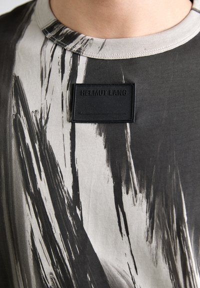 Fél hosszú ujjú fekete és szürke póló absztrakt ecsetvonás mintával, domború fekete címkével, rajta a "HELMUT LANG" felirattal a mellrészen.