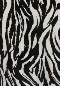 Zebra-striped fabric with bold black and white patterns, featuring a ribbed texture creating visible lines within the design.