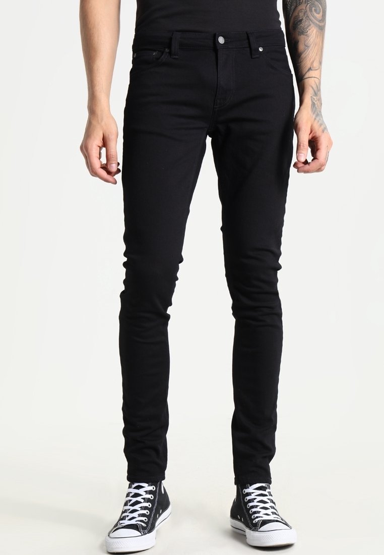 Černé skinny džíny s úzkým střihem, vyrobené z denimu. Mají minimalistický design, pět kapes a zapínání na knoflík. Kombinovány s černými teniskami.