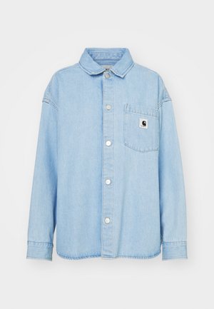 Light blue denim shirt with a button-up front, pointed collar, and long sleeves. Features a chest pocket with a logo patch.