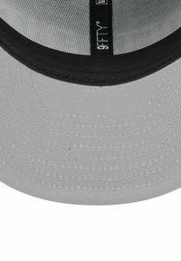 Graue Stoffkappe mit schwarzem, gebogenem Schirm, verfügt über ein Innenfutter aus Mesh und ein eingenähtes Etikett mit der Aufschrift "9FIFTY." Strukturierte Oberflächendetails sichtbar.