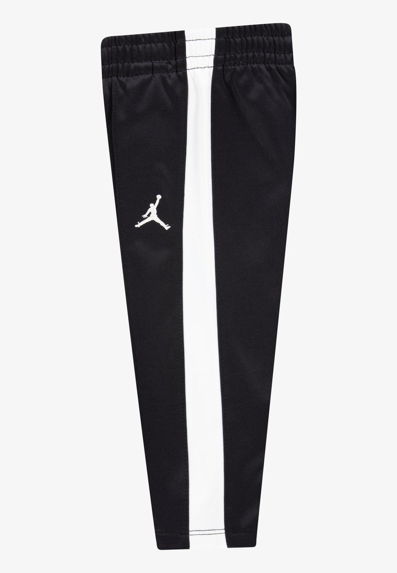Pantaloni sportivi neri con una striscia laterale bianca, dotati di una vita elastica e di un logo Jumpman bianco sulla gamba sinistra. Tessuto dalla superficie liscia.