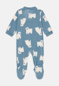 Sininen fleece-haalari, jossa on kaikkialla jääkarhukuvio. Pitkät hihat ja jalkapohjat, ribbikuvioiset hihansuut ja nilkat.