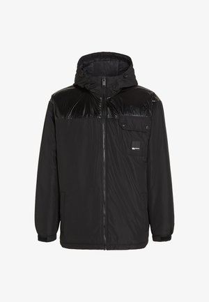 Must must jacket läikiva ülemise osaga, reguleeritava kapuutsiga, ees oleva tõmblukuga ja küljetaskutega. Omab elastseid mansette ja logotähist.