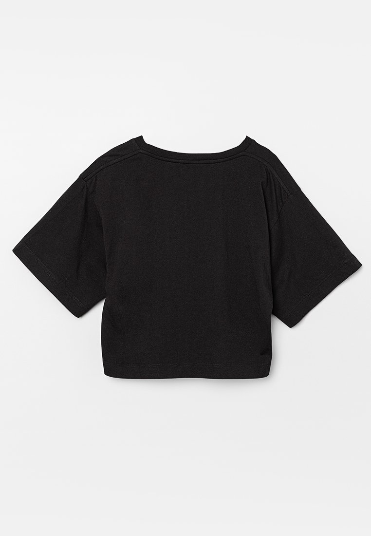 Maglietta nera cropped con maniche corte, realizzata in tessuto morbido, con scollatura rotonda e dettagli di cucitura visibili.