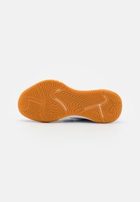 Semelle en caoutchouc orange avec un motif texturé et ondulé. Le talon présente une forme et un contour distincts pour une meilleure adhérence.