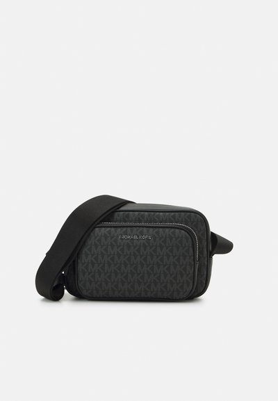 Sac bandoulière noir avec logo MK estampé, poche avant zippée et bandoulière en tissu réglable. Fini en matériau lisse.