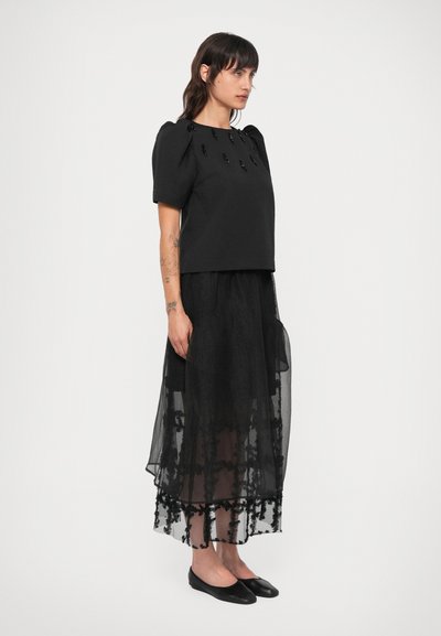 Sort cropped top med puffærmer, prydet med dekorative sorte perler. Lagdelt sort tylnederdel med broderet blomsterdesign og kantdetaljer.