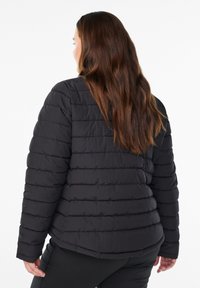 Schwarze Steppjacke mit horizontalem Quiltmuster, hohem Kragen und langen Ärmeln. Leichtes Material und eine leicht entspannte Passform.