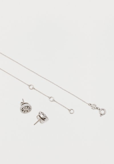 Sidabriniai papuošalų rinkiniai, kuriuose yra subtili grandinėlė ir suderinti auskarai. Auskarai turi apvalią formą su detaliais akcentais.