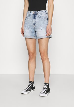 Shorts en denim bleu clair avec ourlet retroussé, légèrement déchirés et au design classique à cinq poches, associés à des baskets montantes noires.