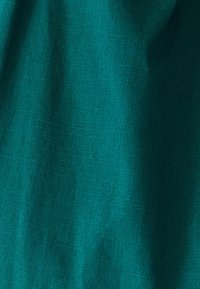 Tiinavärvi linakiud kangas tekstuurse kootud mustriga, millel on kerged kortsud ja pehme langevus, sobib riiete või mööblikatte jaoks.