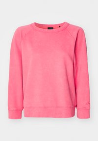 Sudadera rosa con corte relajado, cuello redondo y puños acanalados. Textura suave con un acabado lavado y un sutil logo en la parte inferior de la manga.