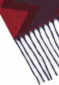Wool scarf in red and navy, featuring a chevron pattern. Edges have fringed navy strands, creating a textured finish.