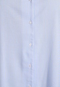 Jasnoniebieska koszula w kratę gingham, z białymi guzikami z przodu, wykonana z miękkiego, fakturowanego materiału.