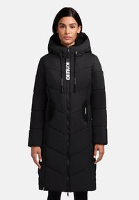 Parka imbottita nera, con chiusura a zip, grande cappuccio e cuciture a contrasto. Tasche laterali con pannelli in rete, dettaglio del logo sui cordini.