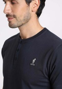 Polo à manches courtes bleu marine en coton, doté d'une patte de boutonnage à trois boutons et d'un logo de cheval brodé avec le détail "EST. 90".