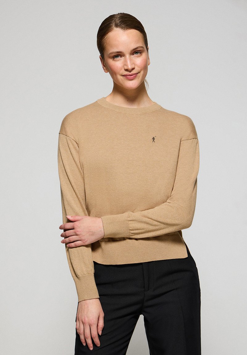 Beige Pullover mit Rundhalsausschnitt und gerippten Bündchen sowie Saum, mit einem kleinen gestickten Logo auf der Brust, aus weichem, leichtem Material.