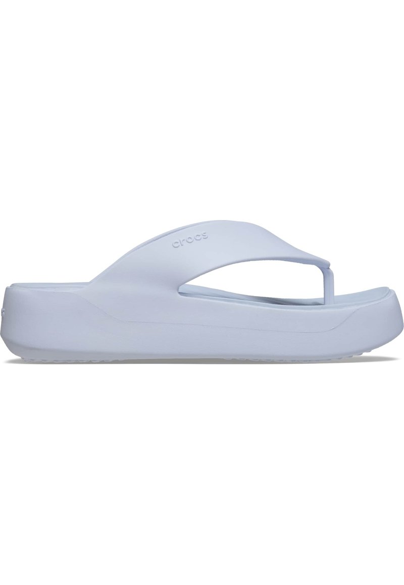 Sandale en caoutchouc blanc avec une plateforme haute, design de bride en T et semelle texturée pour une meilleure adhérence. Branding minimal visible.