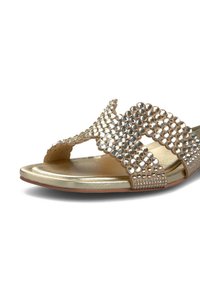 Gouden slide sandaal met strass accenten op een golvende bandontwerp en een gladde metalen voetbed. Open teen stijl met een platte zool.