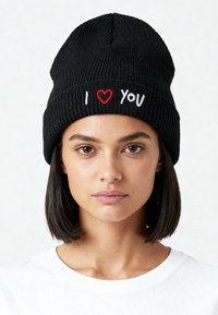 Zwarte geribbelde gebreide muts met geborduurde tekst "I ♥ YOU" in wit en rood. De muts heeft een taps toelopende bovenkant en een strakke pasvorm.