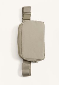 Borsa a spalla rettangolare beige con superficie liscia e testurizzata, tracolla regolabile e chiusura con cerniera. Design minimalista, stile compatto.