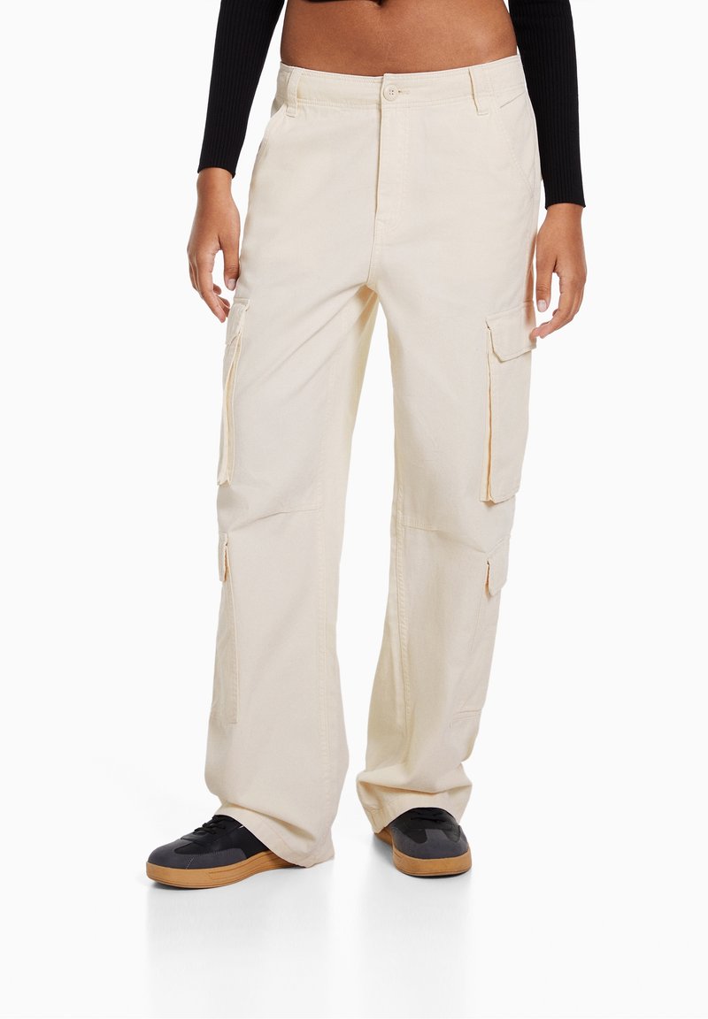 Beige cargobyxor i bomull, med sidofickor, en avslappnad passform och en strukturerad midja med dragkedja och knappstängning fram.