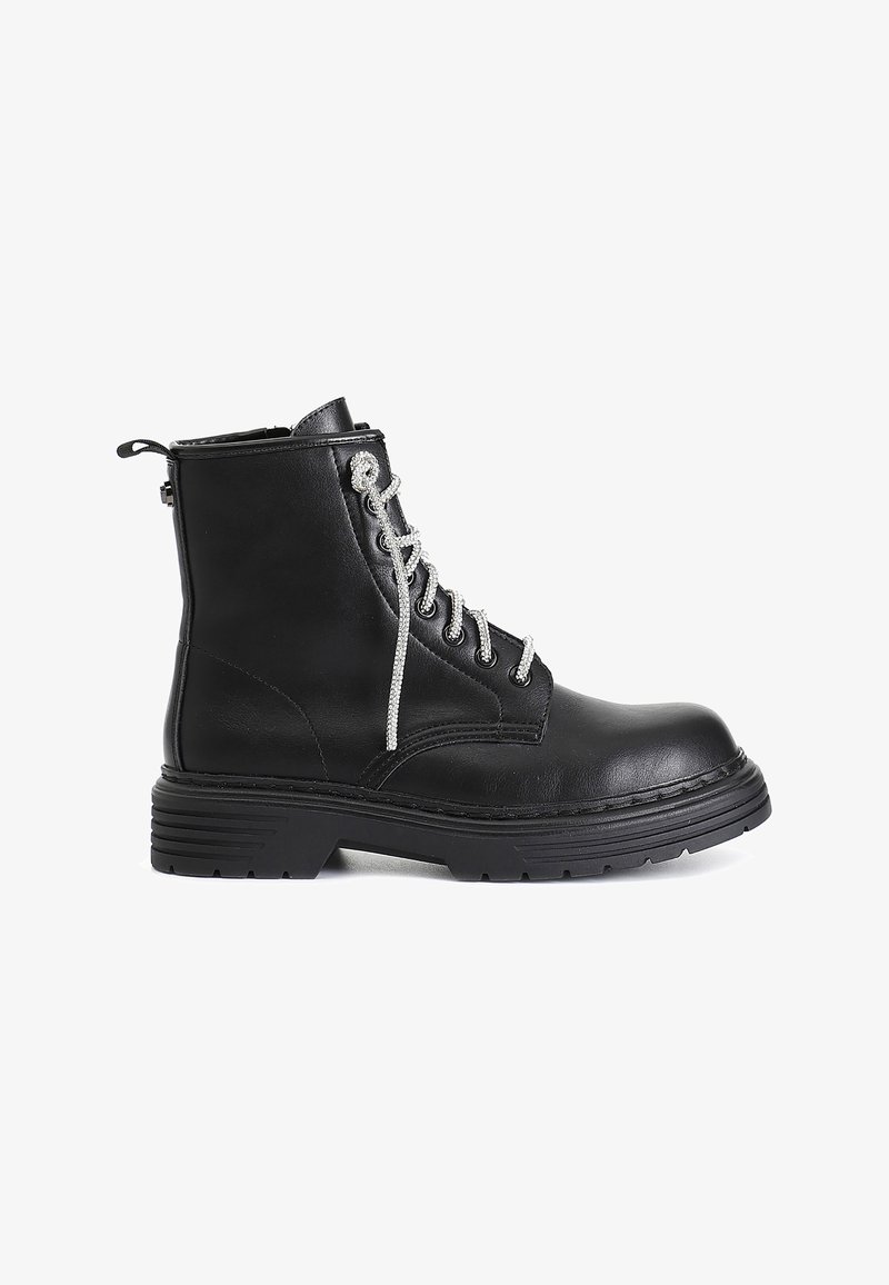 Stivale alla caviglia in pelle nera con lacci argentati, dettaglio con zip sul retro, suola robusta e sottili accenti di cucitura. Stile classico da combattimento.