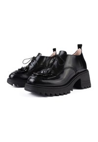 Scarpe in vernice nera con dettagli floreali, design con lacci, suola piattaforma spessa e strutturata, e tacco angolare unico.