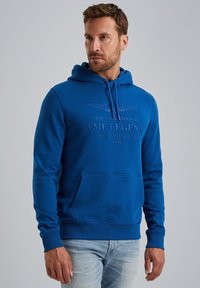 Blue hoodie made of cotton, featuring a front pocket, adjustable drawstring hood, and printed logo detail on the chest.