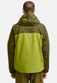 Chaqueta impermeable verde y marrón con capucha, que presenta un diseño a bloques de colores en contraste, puños elásticos y una textura suave.