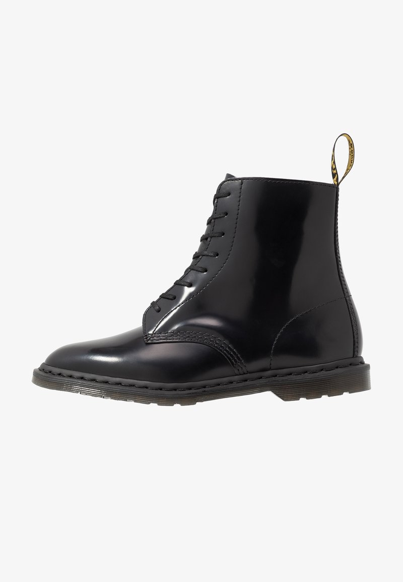 Bottine en cuir noir avec bout rond, lacets robustes, finition lisse, languette de tirage jaune et semelle en caoutchouc striée.