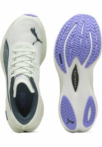 Scarpa sportiva verde chiaro con upper in rete, accenti viola sulla suola e suola in gomma testurizzata con un motivo battistrada unico.