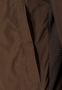 Bolsillo de tela marrón con bordes rectos y costura contrastante, que cuenta con un forro interior negro texturizado.