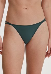 Dunkelgrüne Bikiniunterteile mit dünnen, verstellbaren Seitenträgern. Der Stoff hat eine glatte Textur und ein minimalistisches Deckungsdesign.