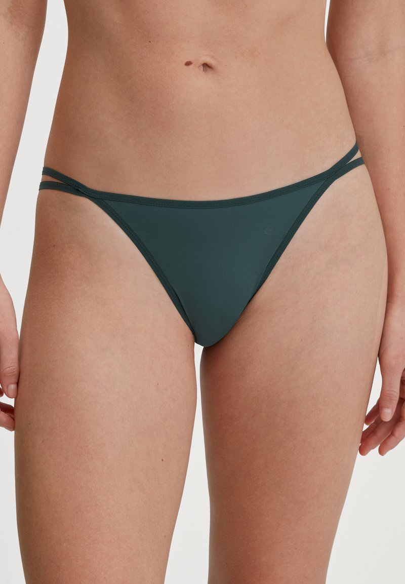 Dunkelgrüne Bikiniunterteile mit dünnen, verstellbaren Seitenträgern. Der Stoff hat eine glatte Textur und ein minimalistisches Deckungsdesign.