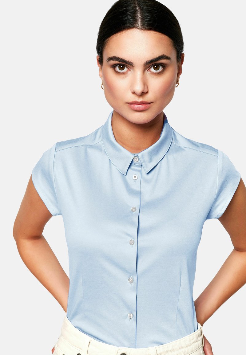Light blue short-sleeve collared shirt made of smooth fabric, featuring a button front and a fitted design with side slits.