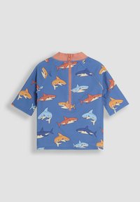 Sininen lasten rash guard, jossa on lyhyet hihat, korkea kaulus ja takana vetoketju. Koristeltu erilaisilla värikkäillä hai-kuvioilla.