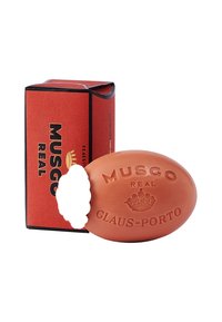 Ovaler orangefarbener Seife mit geprägt eingeprägtem Text "MUSGO REAL GLAUS-PORTO." Begleitet von einer rechteckigen roten Box mit schwarzen Akzenten.