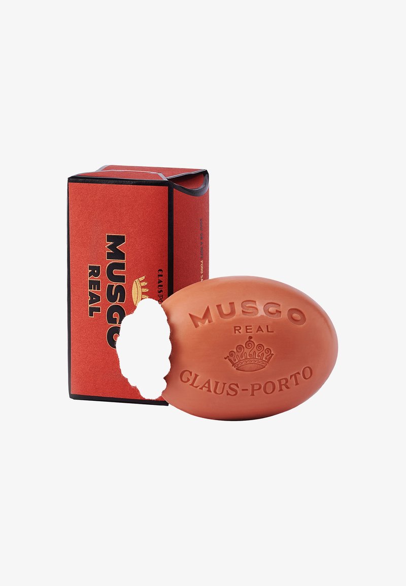 Oval orange soap with embossed text "MUSGO REAL GLAUS-PORTO." Accompanied by a rectangular red box with black accents.