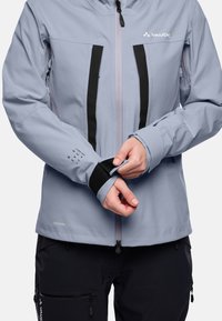 Light blue waterproof jacket with black accents, zippered pockets, and adjustable cuffs featuring Velcro. Material labeled "Ceplex Pro."