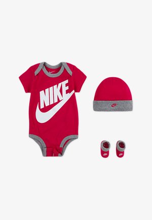 Raudonas romperis su pilkais akcentais, turintis didelį baltą Nike logotipą, kartu su derančiu pilku ir raudonu kepurėle bei bateliais.