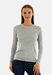Maglione grigio chiaro a maniche lunghe con texture a coste, dotato di scollatura a girocollo e di un piccolo logo sul lato inferiore. Vestibilità casual.