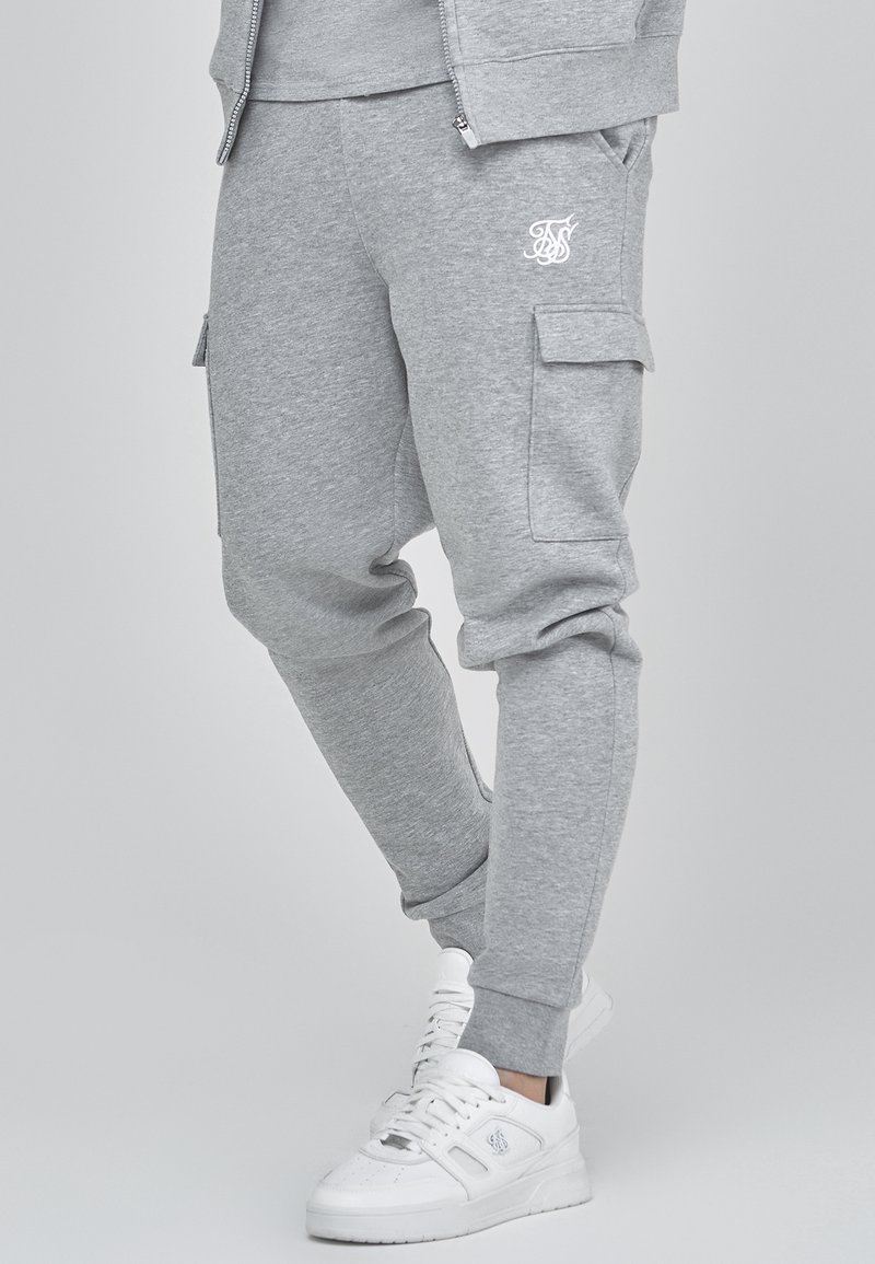 Graue Jogginghose aus einem weichen Baumwollmix, mit Cargo-Taschen, gerippten Bündchen und einem weißen Logodetail am Oberschenkel.