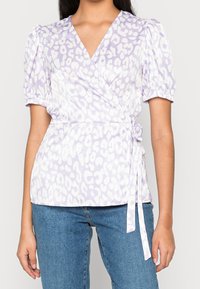 Maglia avvolgente in lavanda con maniche a sbuffo corte, caratterizzata da un motivo maculato bianco. Dettaglio in vita annodato; tessuto morbido; vestibilità casual.
