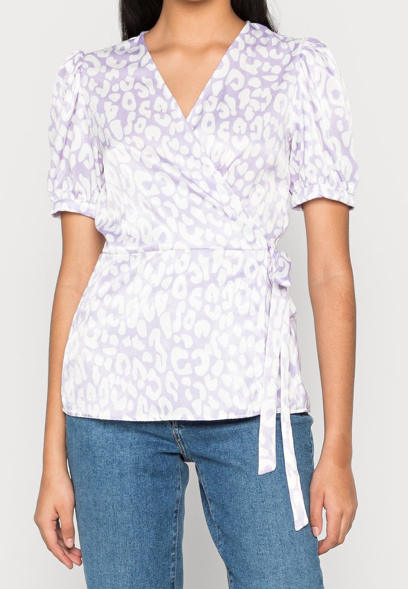 Maglia avvolgente in lavanda con maniche a sbuffo corte, caratterizzata da un motivo maculato bianco. Dettaglio in vita annodato; tessuto morbido; vestibilità casual.