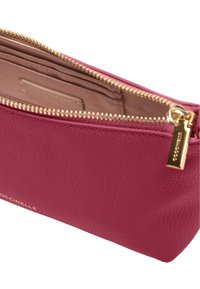 Pochette cosmétique en cuir rose avec une surface texturée, fermeture éclair dorée et étiquette intérieure ; son design rectangulaire offre un espace de rangement généreux.