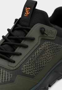 Zeleni zunanji čevelj z teksturiranim zgornjim delom, črnimi vezalkami in gumijastim podplatom. Opremljen z oranžnim logotipom in napisom "SALAMANDER".