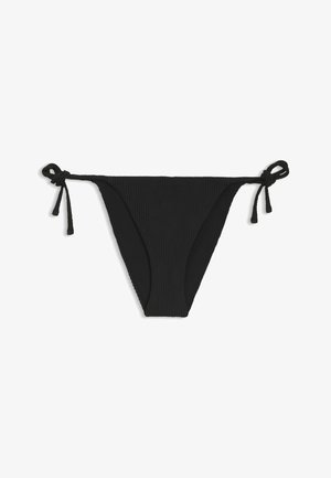 Braguitas de bikini negras con lazos laterales y un sutil patrón floral texturizado en la tela, colocadas planas sobre un fondo blanco.
