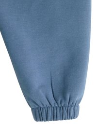 Blå sweatshirtærme lavet af blødt, struktureret stof med samlet elastik. Materialet er glat og viser et afslappet pasformdesign.